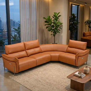 Brown leather sectional sofa in a modern living room with plants and city view.