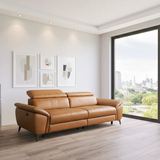 Brown leather sofa in a modern living room with large windows and abstract art on the wall.
