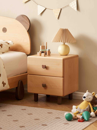 Children's bedroom with wooden nightstand, lamp, and toys.