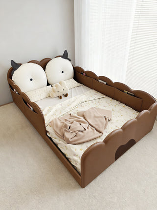 Children's bed with cartoon character headboard in a room with a window.