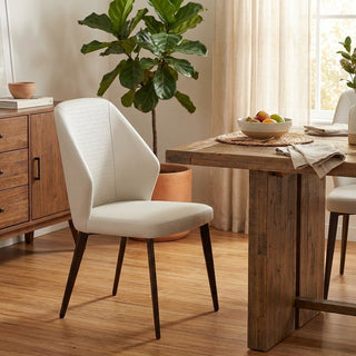 Dining room with a wooden table, beige chair, and potted plant