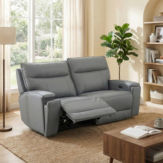 Gray leather sofa in a living room with a coffee table and book
