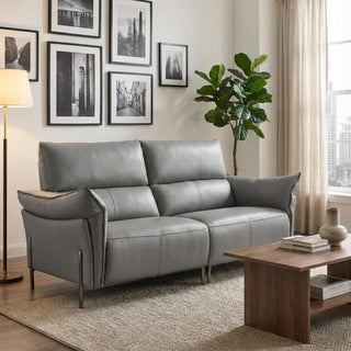 Gray sofa in a living room with a wooden coffee table, lamp, and framed pictures on the wall.