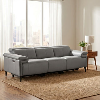 grey sectional sofa in a living room with large windows and a side table.