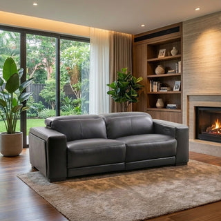 Modern living room with a grey sofa, bookshelf, and fireplace.