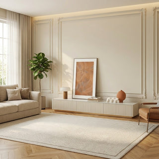 Modern living room with beige sofa, decorative rug, and wall art.