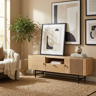 Modern living room with wooden console table, abstract art, and plant.