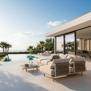 Modern outdoor furniture set by a pool with a clear blue sky and palm trees in the background.
