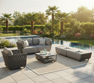 Outdoor patio furniture set with a pool and garden in the background