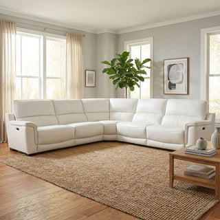 White leather sectional sofa in a living room with a plant and framed art on the wall.