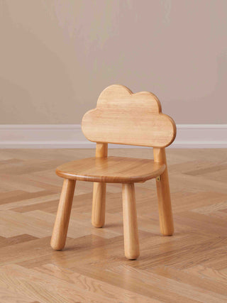 Wooden chair shaped like a cloud on a wooden floor with a beige wall background