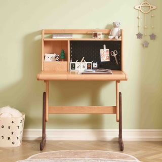 Wooden children's desk with chalkboard, toys, and decor against a light green wall.