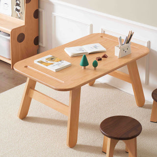 Wooden children's table with books and toys in a room setting