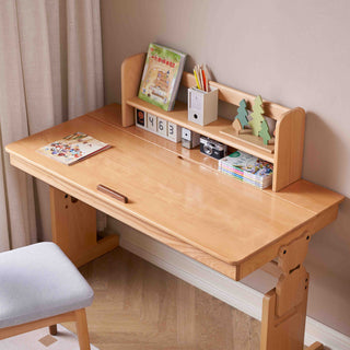 Wooden kids study desk with shelves and stationery items in a room setting.