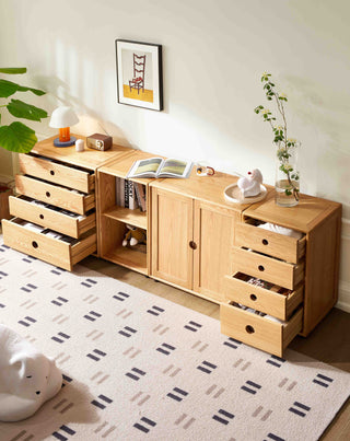 Wooden sideboard with drawers and shelves in a room with a rug and plant.
